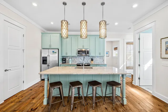 a dining room filled chandelier and wooden floor
