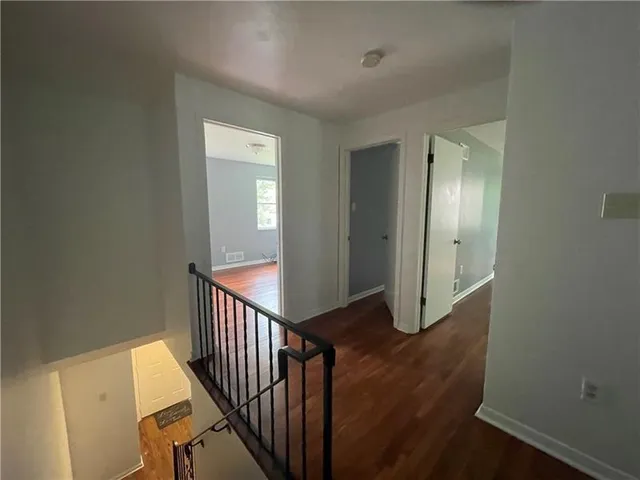 a view of a hallway with wooden floor and entryway