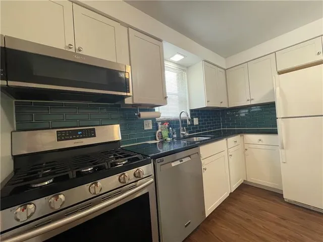 a kitchen with granite countertop cabinets and steel stainless steel appliances
