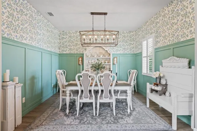 a dining room with furniture potted plants and wooden floor