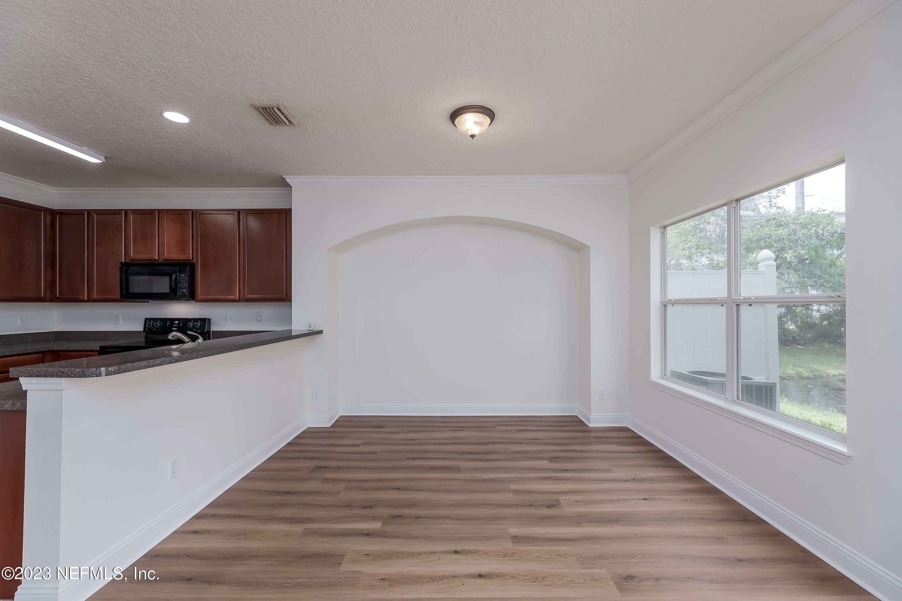 5260 Collins Road, Unit 1102 Jacksonville, FL 32244 - Photo 8 of 23 a view of a kitchen with wooden floor and electronic appliances