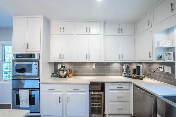 a kitchen with stainless steel appliances granite countertop a sink a stove and cabinets