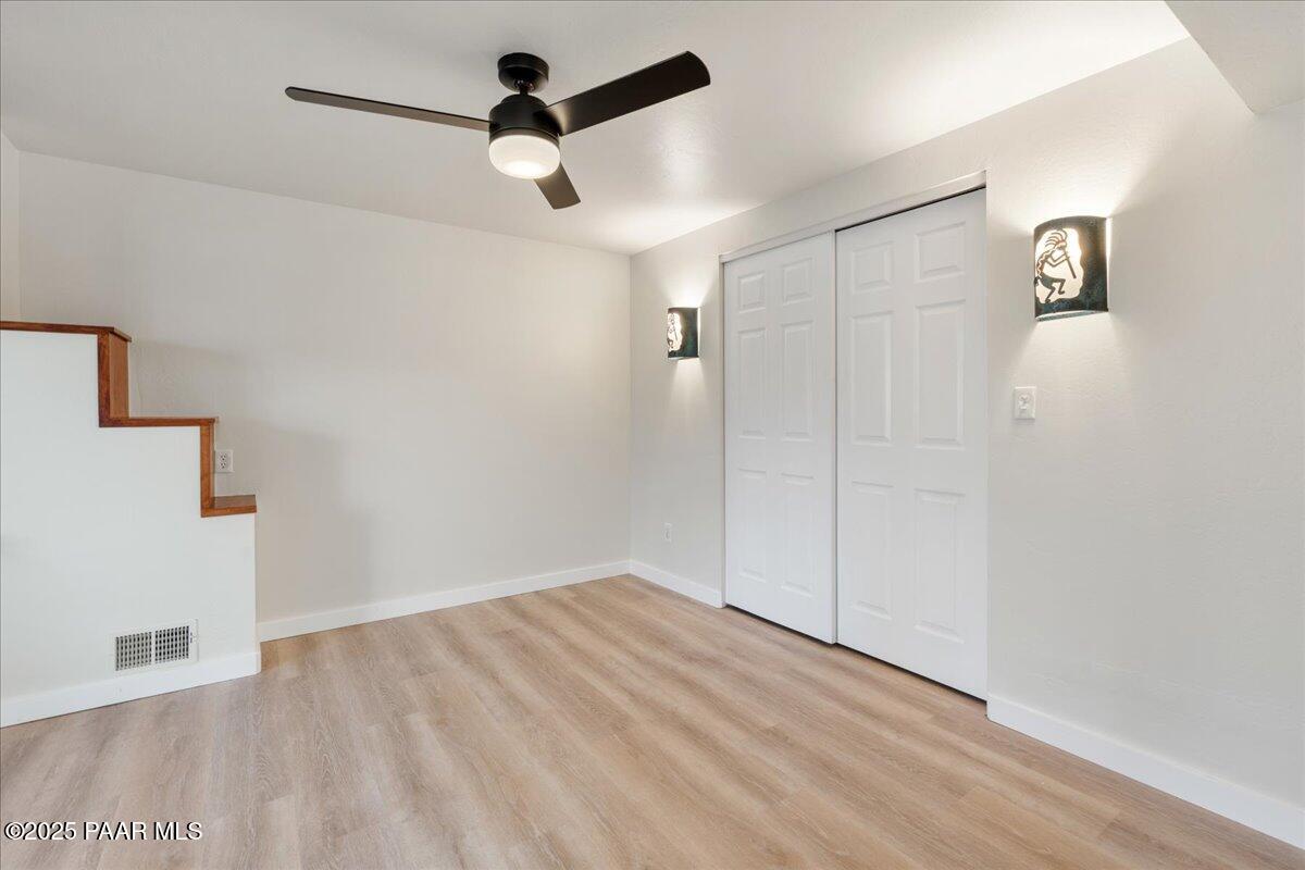 345 Banning Creek Road Prescott, AZ 86303 - Photo 32 of 41 an empty room with a ceiling fan and wooden floor