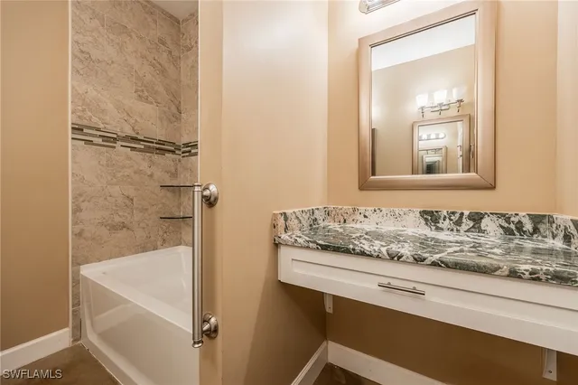 a bathroom with a granite countertop sink a mirror and a shower