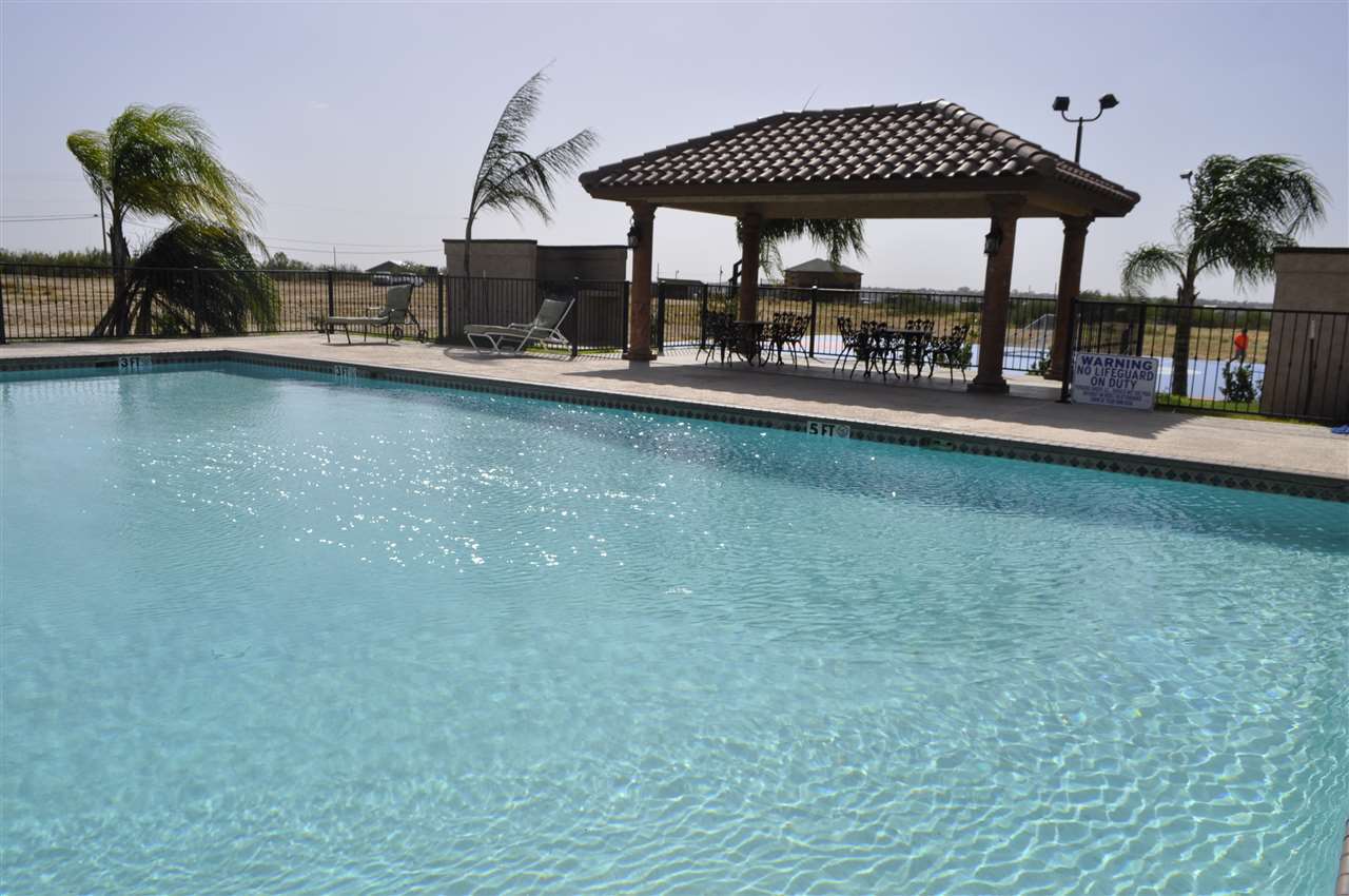 8216 Casa Verde Road, Unit E163 Laredo, TX 78041 - Photo 16 of 20 a view of patio with chairs and table under an umbrella