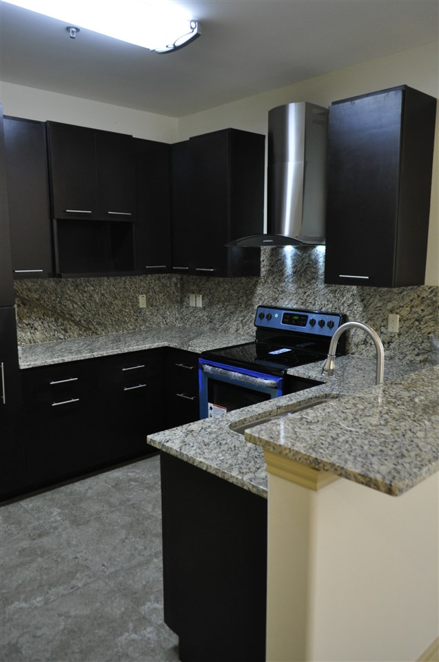 8216 Casa Verde Road, Unit E163 Laredo, TX 78041 - Photo 4 of 20 a kitchen with granite countertop stainless steel appliances and cabinets