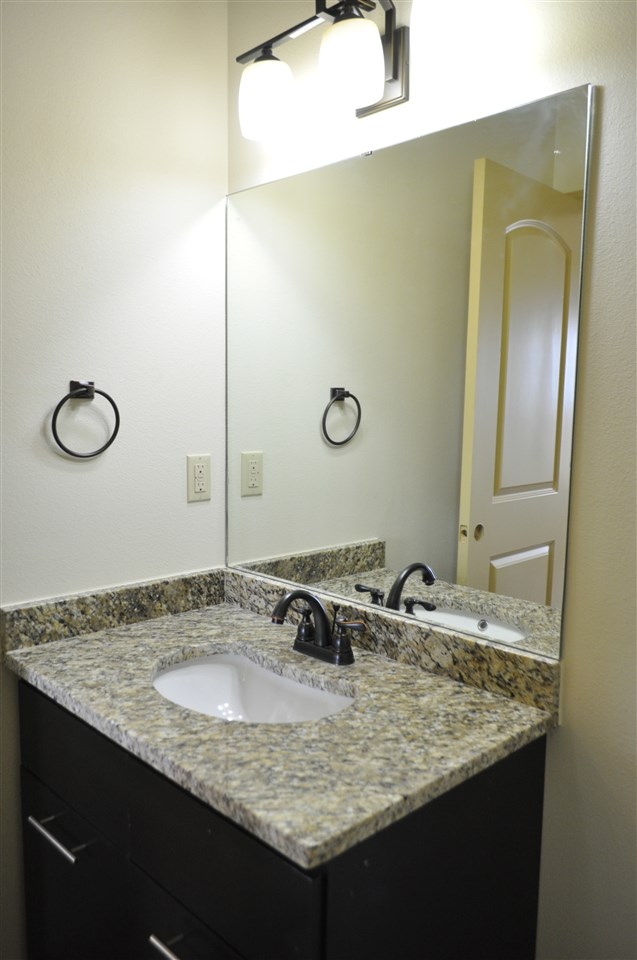 8216 Casa Verde Road, Unit E163 Laredo, TX 78041 - Photo 8 of 20 a bathroom with a granite countertop sink and a mirror
