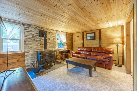 a living room with furniture a dining table wooden floor and a fireplace
