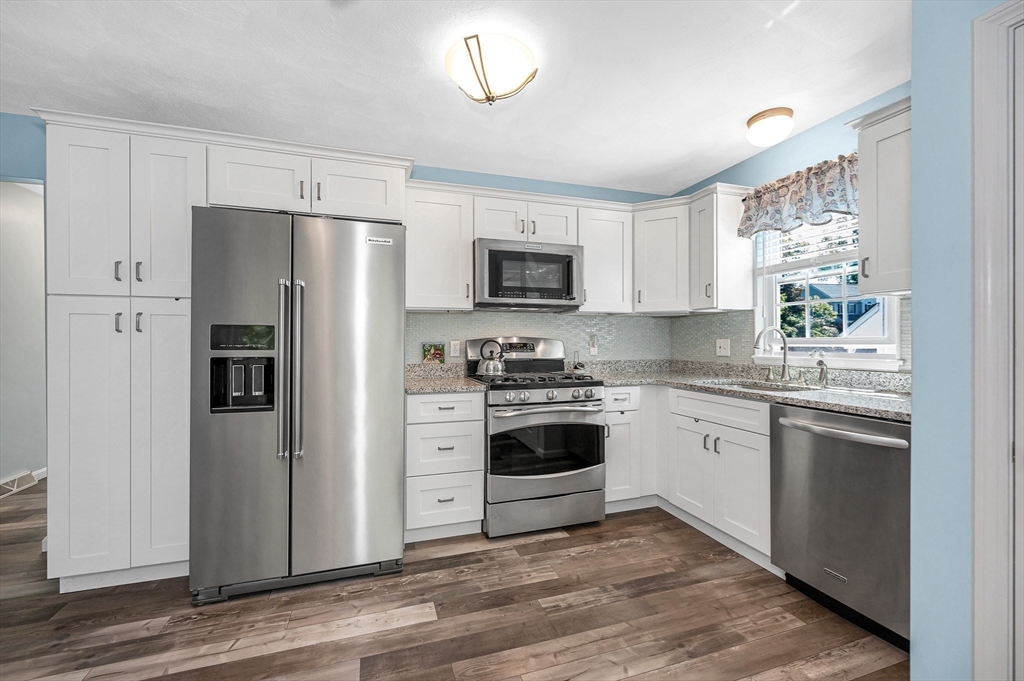 218 Acropolis Road Lowell, MA 01854 - Photo 11 of 39 a kitchen with granite countertop a refrigerator stove and sink