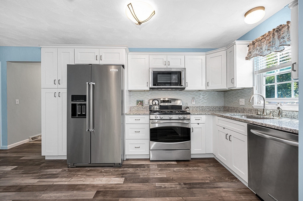 218 Acropolis Road Lowell, MA 01854 - Photo 12 of 39 a kitchen with a refrigerator stove and sink