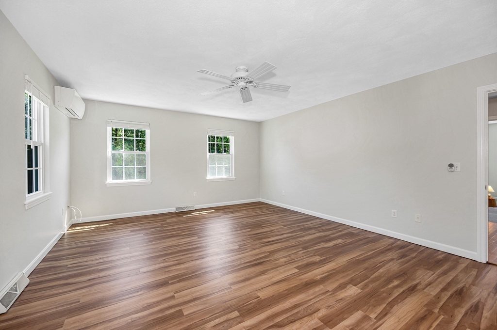 218 Acropolis Road Lowell, MA 01854 - Photo 21 of 39 an empty room with wooden floor ceiling fan and windows