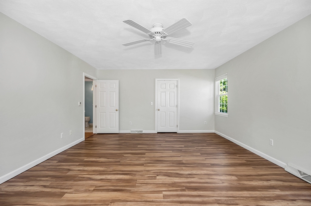 218 Acropolis Road Lowell, MA 01854 - Photo 22 of 39 a view of an empty room with wooden floor and a ceiling fan