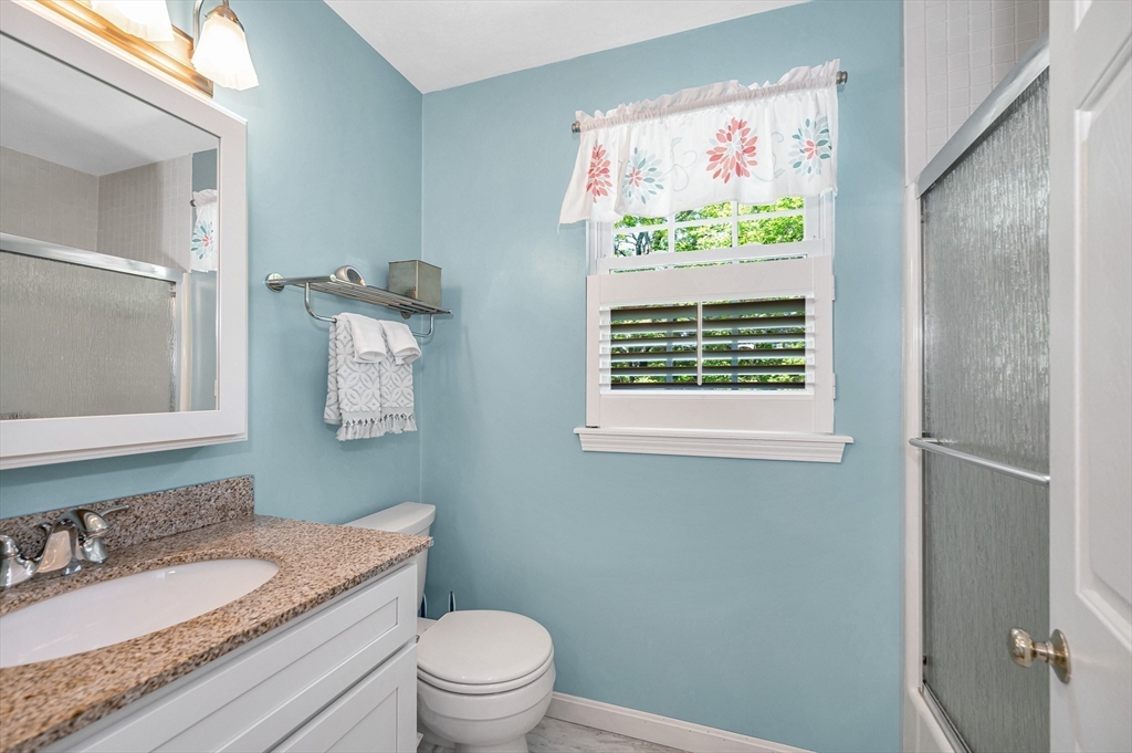 218 Acropolis Road Lowell, MA 01854 - Photo 23 of 39 a bathroom with a granite countertop toilet a sink and a mirror