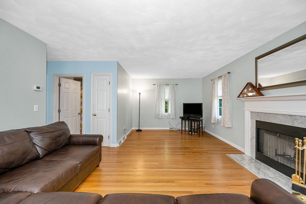 218 Acropolis Road Lowell, MA 01854 - Photo 6 of 39 a living room with furniture and a fireplace