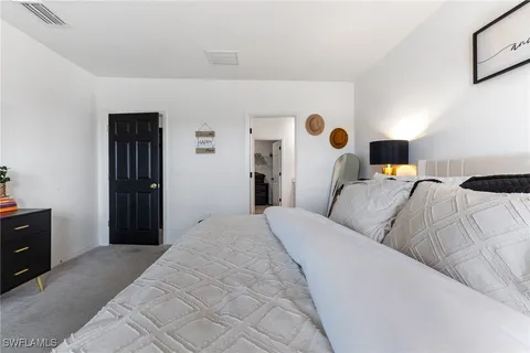 a bedroom with a bed and a lamp