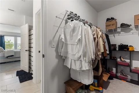 a view of walk in closet with clothes and shoes
