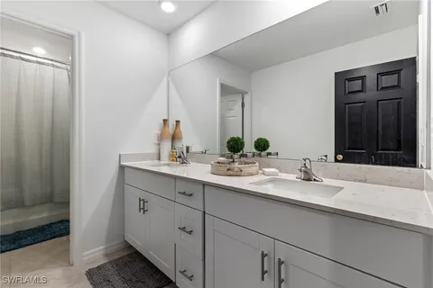 a bathroom with a double vanity sink and a mirror
