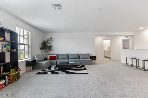 a living room with furniture gym equipment and a flat screen tv