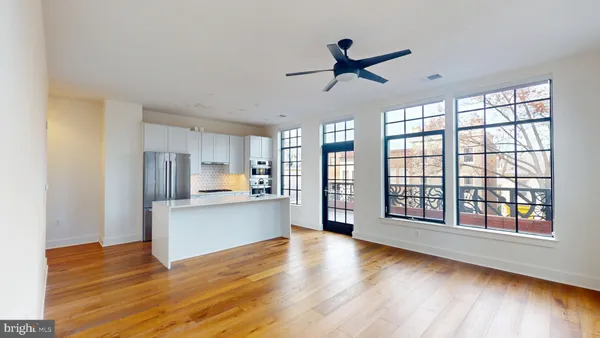 a view of an empty room with window and wooden floor