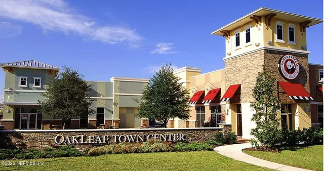 a view of a house with sign board and yard