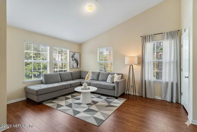 a living room with furniture wooden floor and a large window