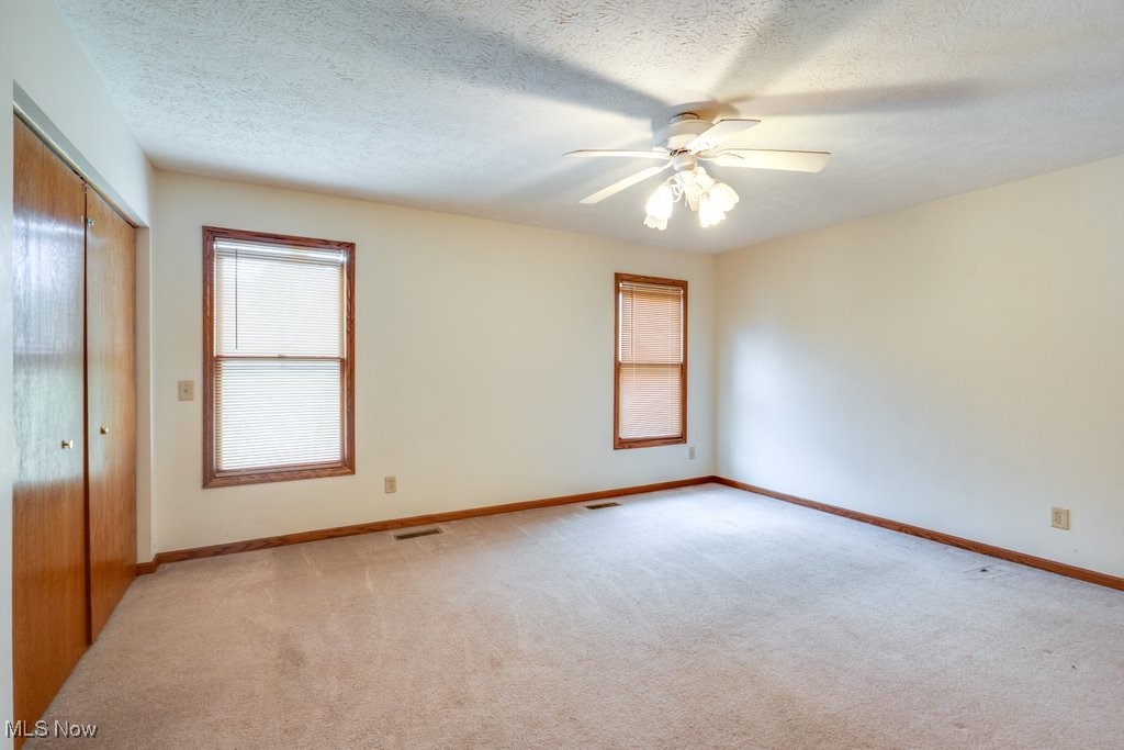 3362 Sunnybrook Road Kent, OH 44240 - Photo 23 of 50 Unfurnished bedroom with light carpet, a textured ceiling, a closet, and ceiling fan