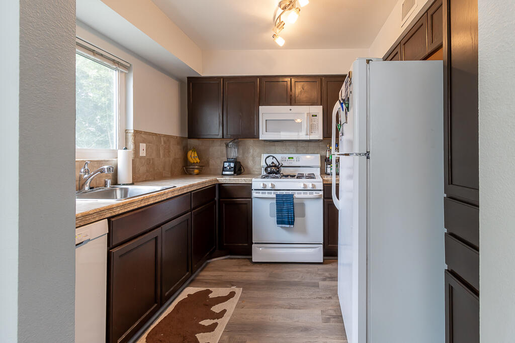 31355 The Old Road, Unit E Castaic, CA 91384 - Photo 14 of 38 a kitchen with a sink a refrigerator and cabinets