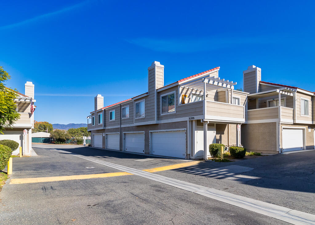 31355 The Old Road, Unit E Castaic, CA 91384 - Photo 38 of 38 a view of a house with a patio and a yard