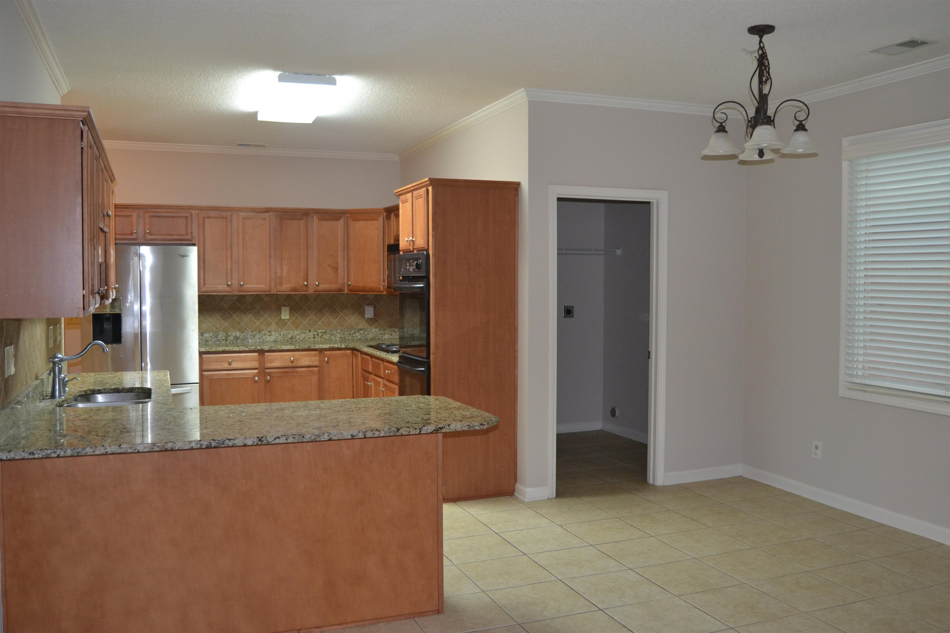 10486 Juneau Way Collierville, TN 38017 - Photo 15 of 33 Kitchen with kitchen peninsula, decorative backsplash, light tile patterned flooring, and stainless steel refrigerator with ice dispenser