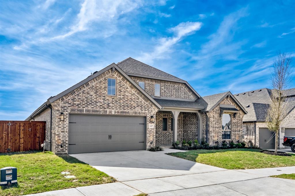 147 Derrett Lane Rhome, TX 76078 - Photo 25 of 28 View of front of home with brick siding, concrete driveway, a shingled roof, and an attached garage