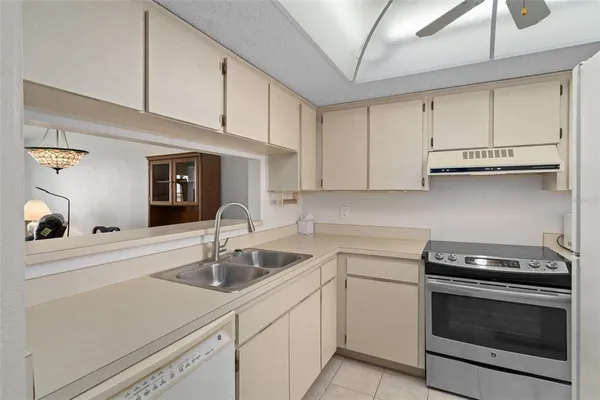a kitchen with a sink a stove top oven and cabinets
