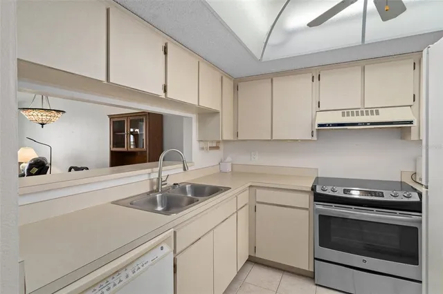 a kitchen with a sink a stove top oven and cabinets
