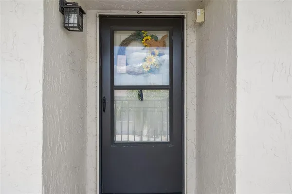 a view of a hallway with wooden floor and a living room