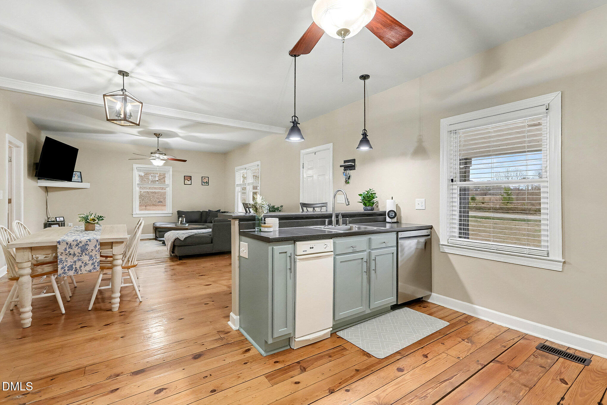 7228 Cleveland School Road Garner, NC 27529 - Photo 13 of 28 a kitchen with stainless steel appliances granite countertop a stove top oven a sink dishwasher a dining table and chairs with wooden floor