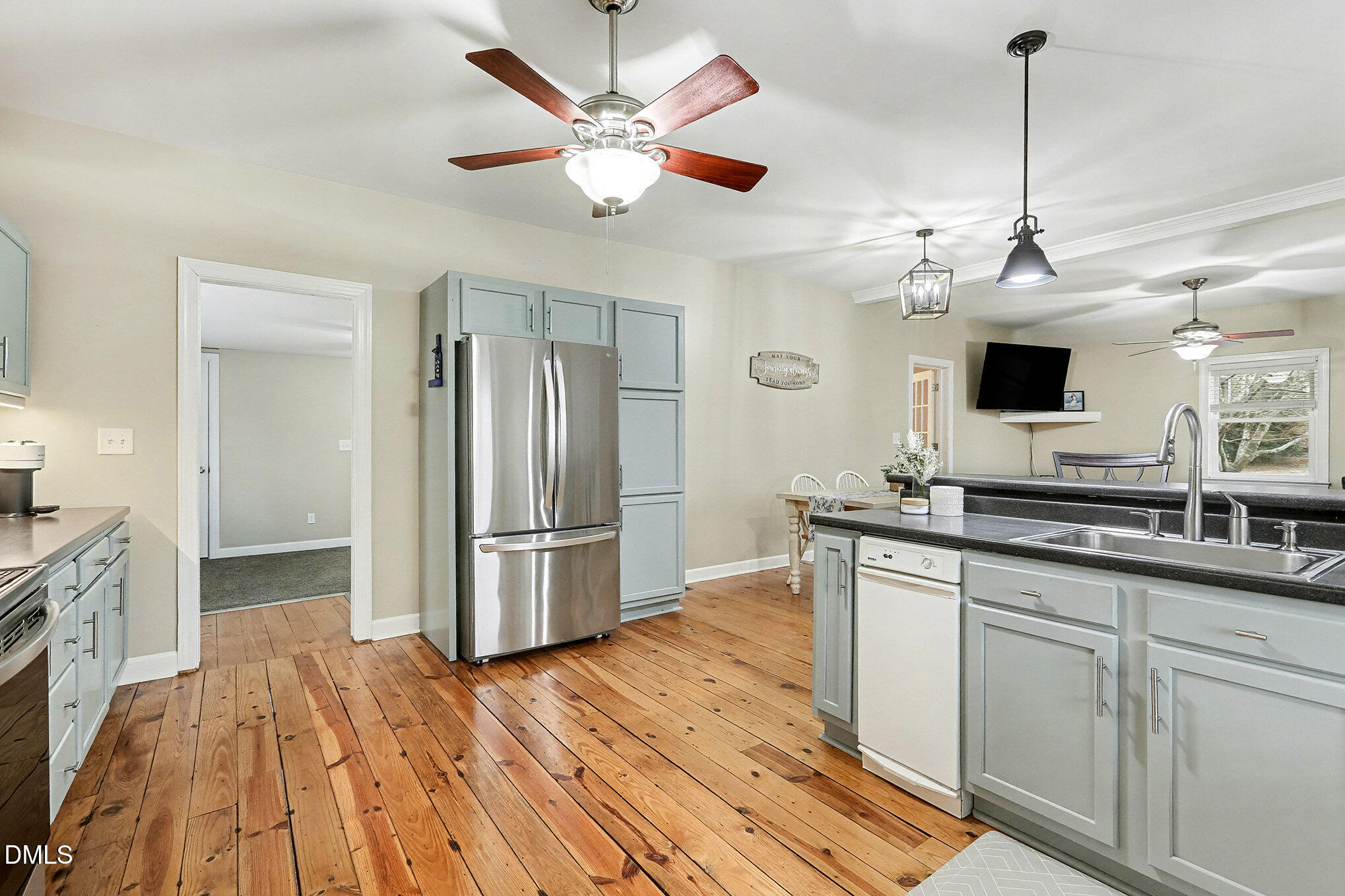 7228 Cleveland School Road Garner, NC 27529 - Photo 14 of 28 a kitchen with stainless steel appliances granite countertop a refrigerator a sink dishwasher a stove and white countertops with wooden floor