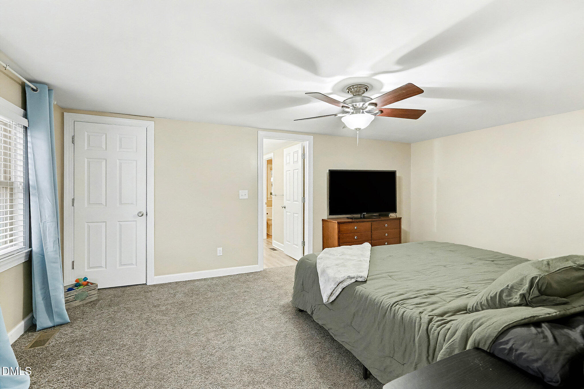 7228 Cleveland School Road Garner, NC 27529 - Photo 17 of 28 a bedroom with a bed window and a flat screen tv