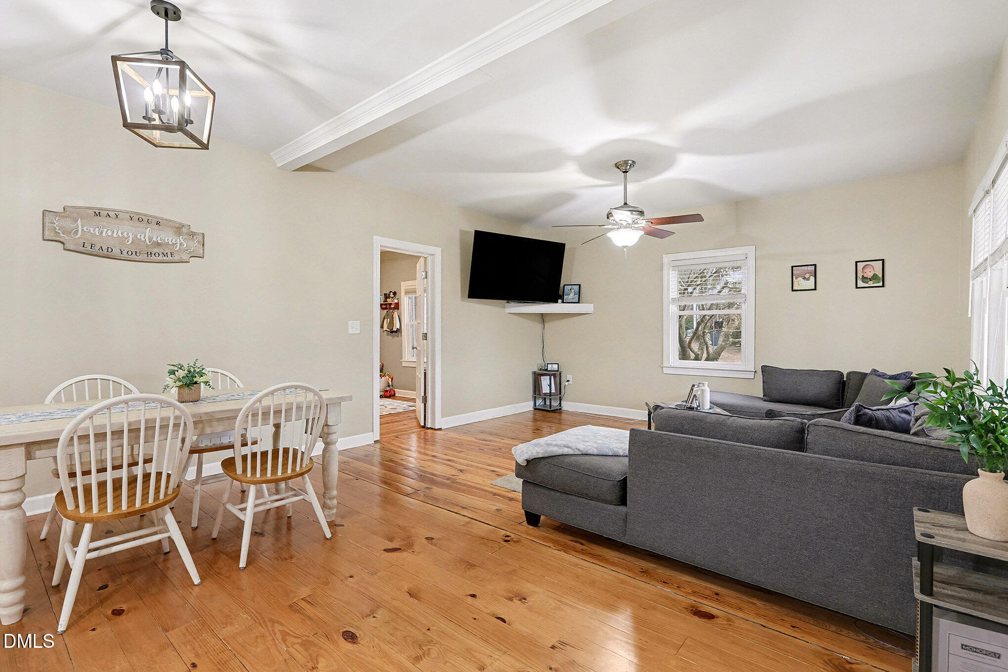 7228 Cleveland School Road Garner, NC 27529 - Photo 9 of 28 a living room with furniture a chandelier and a flat screen tv