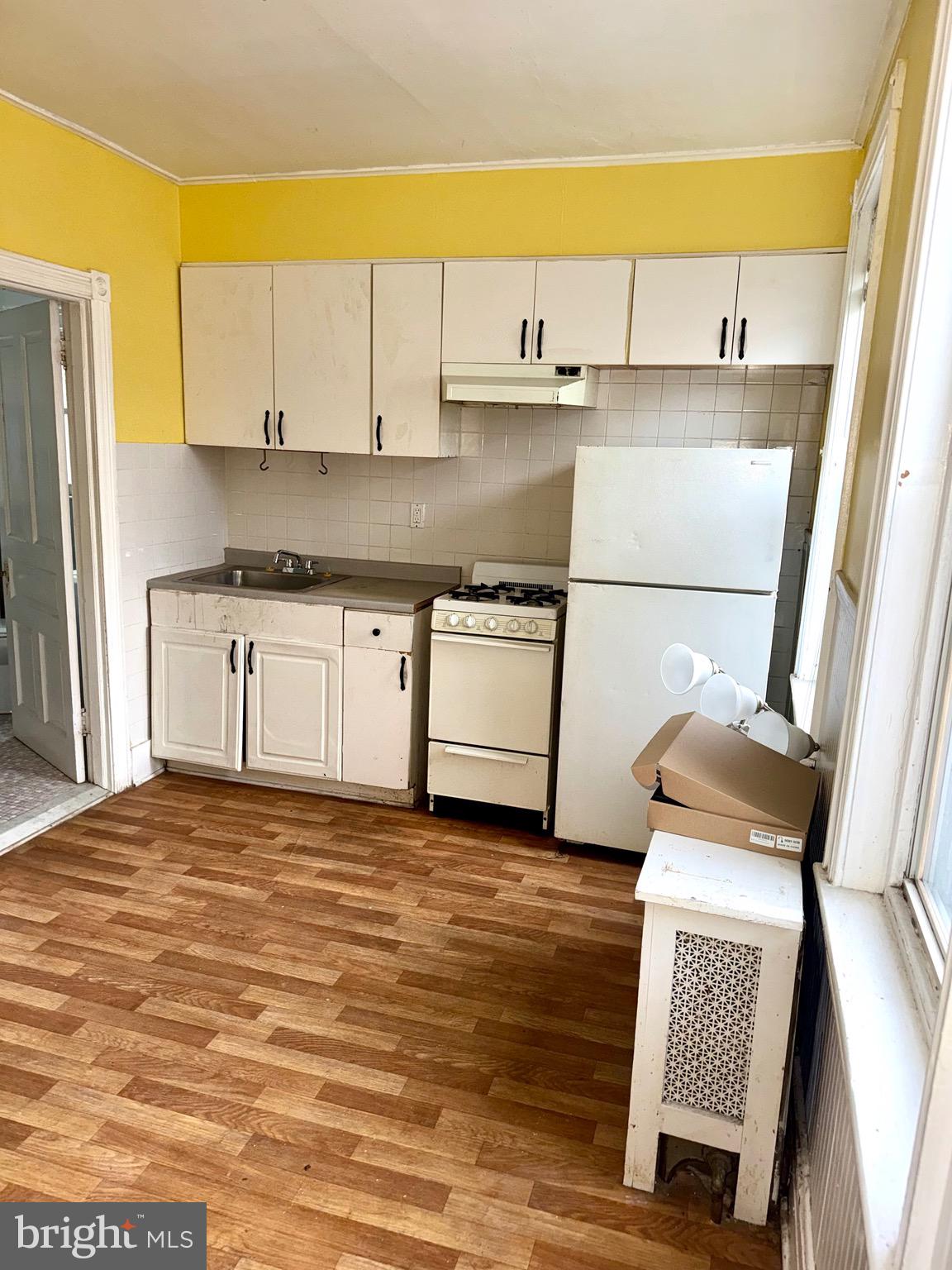 4515 Comly Street Philadelphia, PA 19135 - Photo 21 of 38 a kitchen with stainless steel appliances granite countertop a sink stove and white cabinets