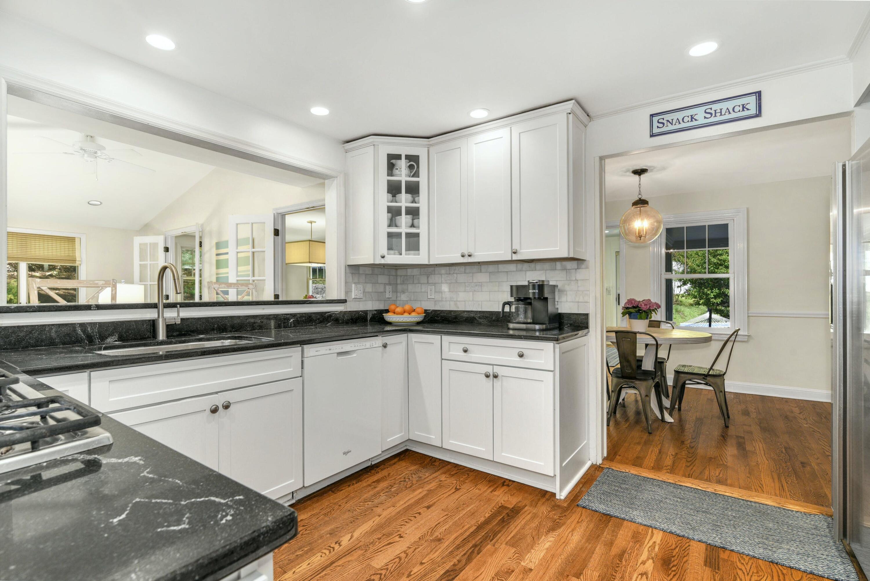 1 Fairmead Road Darien, CT 06820 - Photo 9 of 40 a large white kitchen with stainless steel appliances granite countertop a stove a sink a dining table and chairs