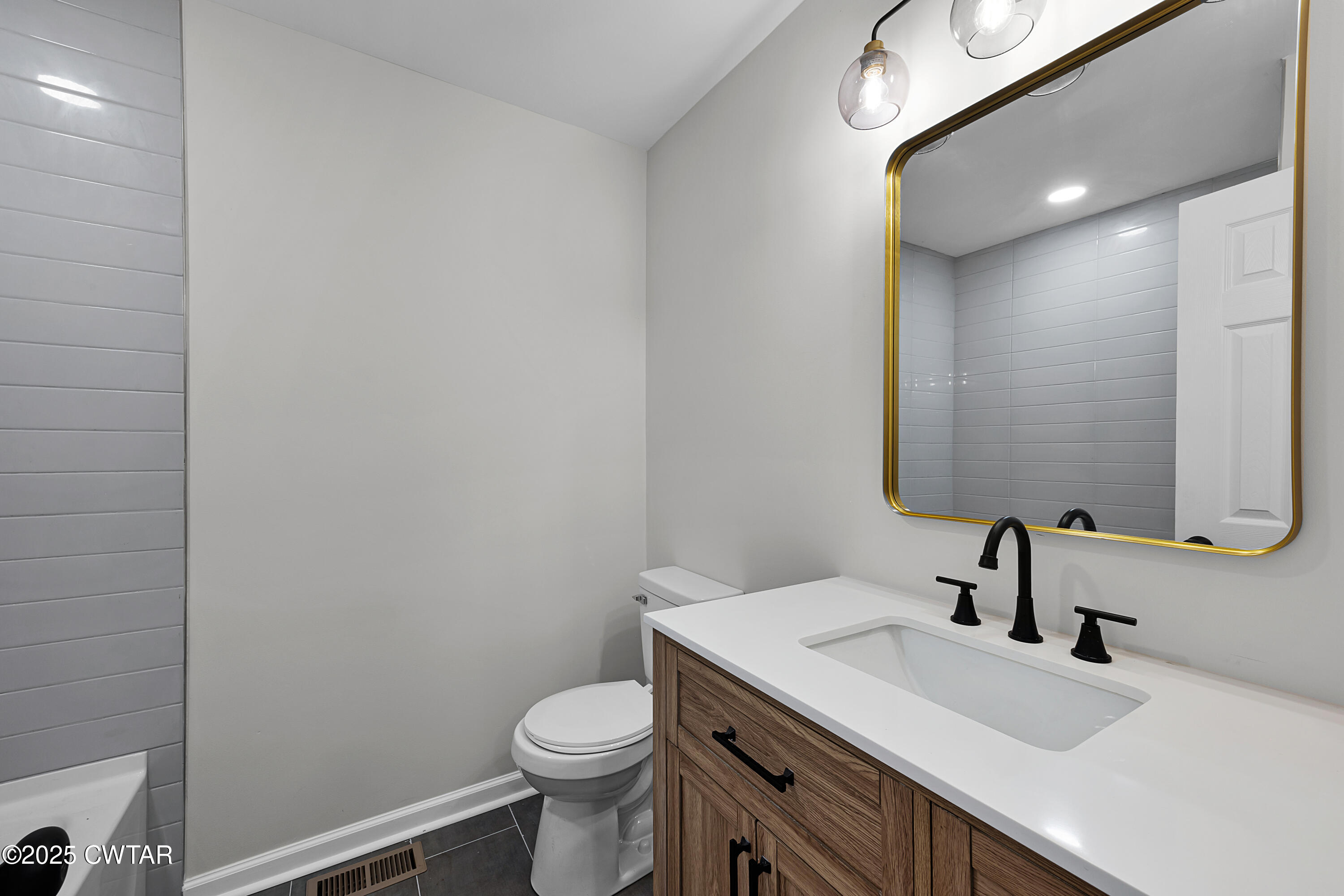 144 McLeary Road Jackson, TN 38305 - Photo 15 of 23 a bathroom with a sink a toilet and mirror