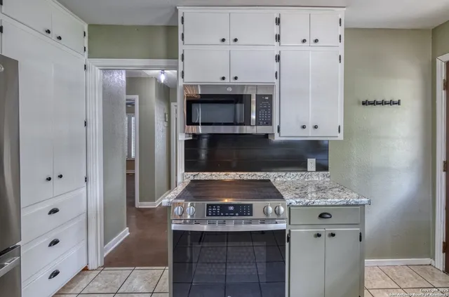 a kitchen with stainless steel appliances granite countertop a stove and a refrigerator