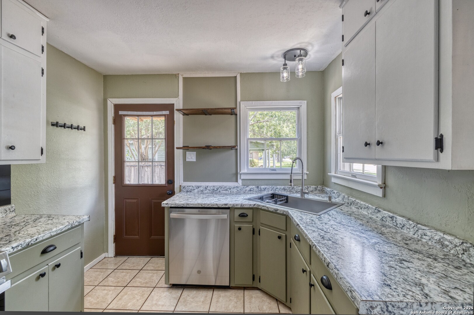 829 Maple Street Uvalde, TX 78801 - Photo 13 of 33 a kitchen with granite countertop a sink and a stove