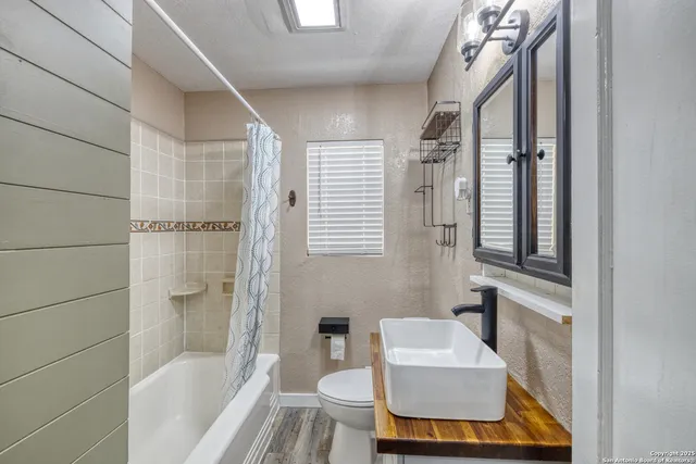 a bathroom with a tub shower and sink