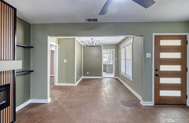 an empty room with windows and cabinet