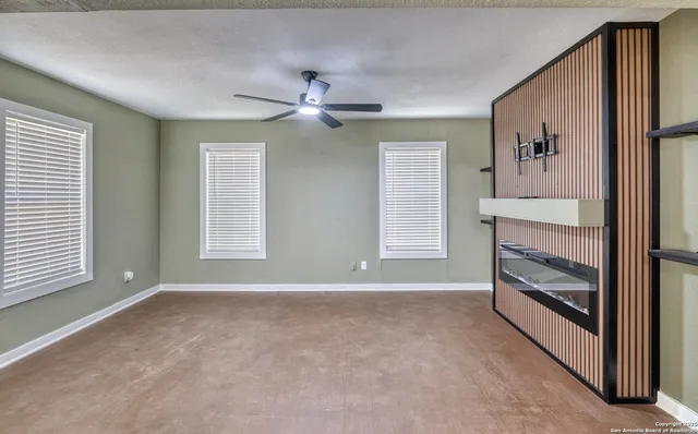 a view of livingroom with window fireplace and ceiling fan