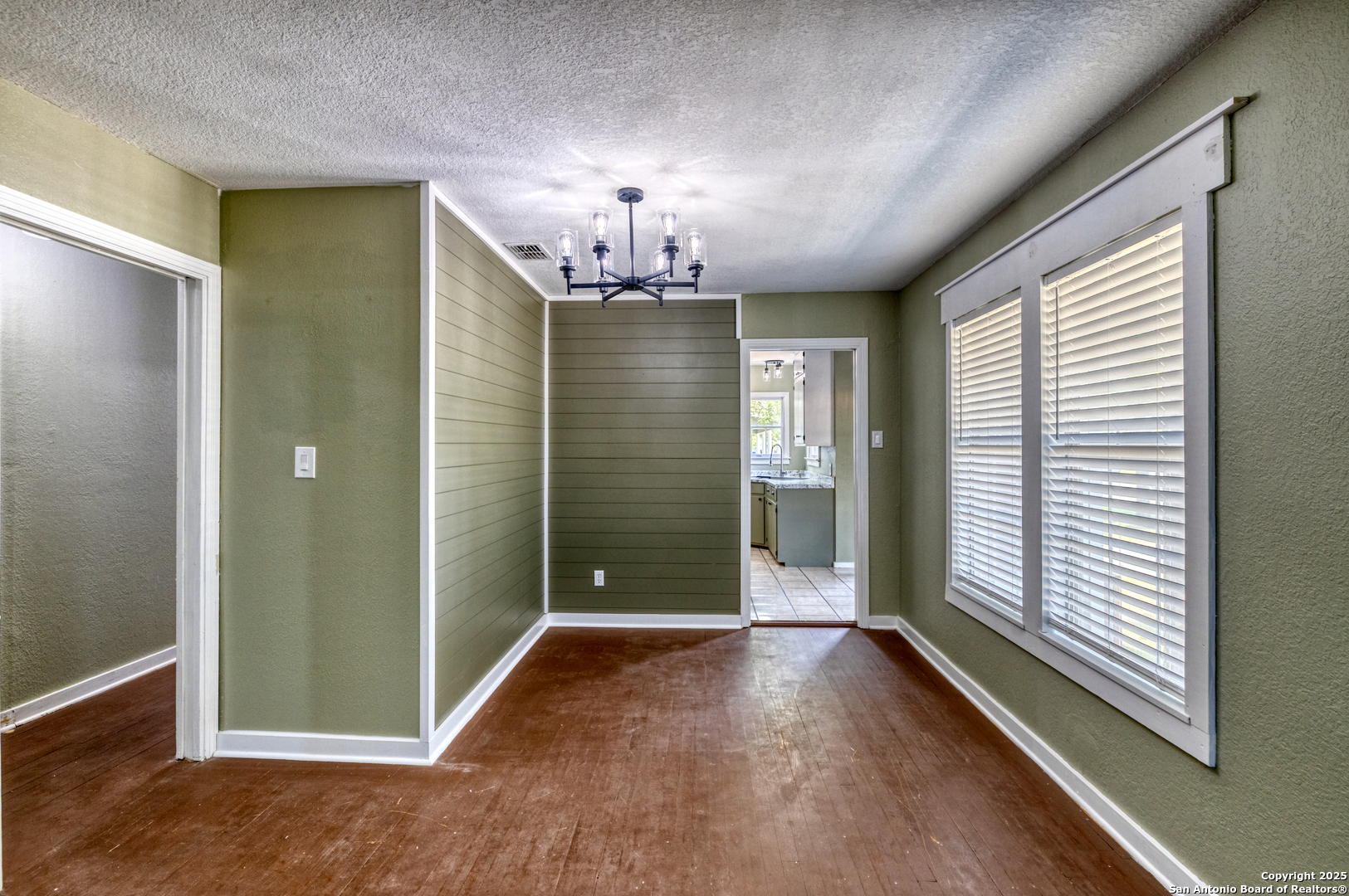 829 Maple Street Uvalde, TX 78801 - Photo 9 of 33 wooden floor in an empty room with a window