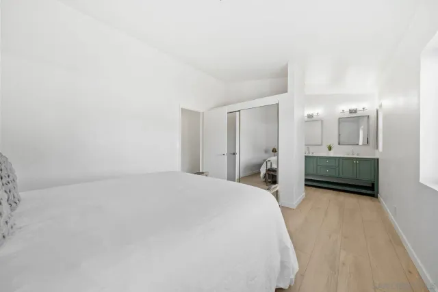 a spacious bedroom with a bed and a mirror