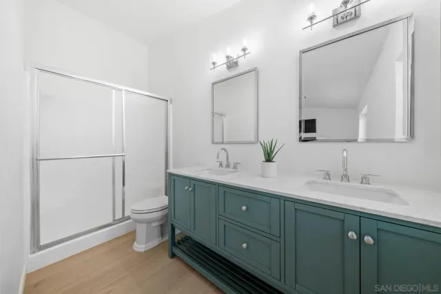 a bathroom with a double vanity sink mirror and toilet
