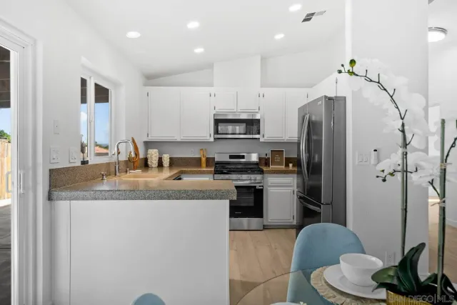 a kitchen with stainless steel appliances granite countertop a refrigerator a stove a sink and a microwave