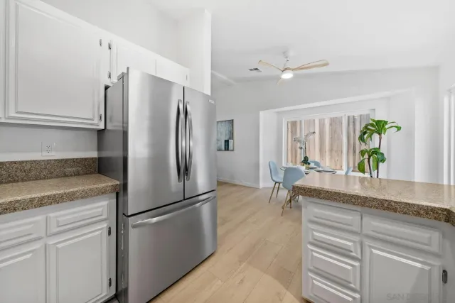 a kitchen with stainless steel appliances granite countertop a refrigerator a sink a stove and a refrigerator